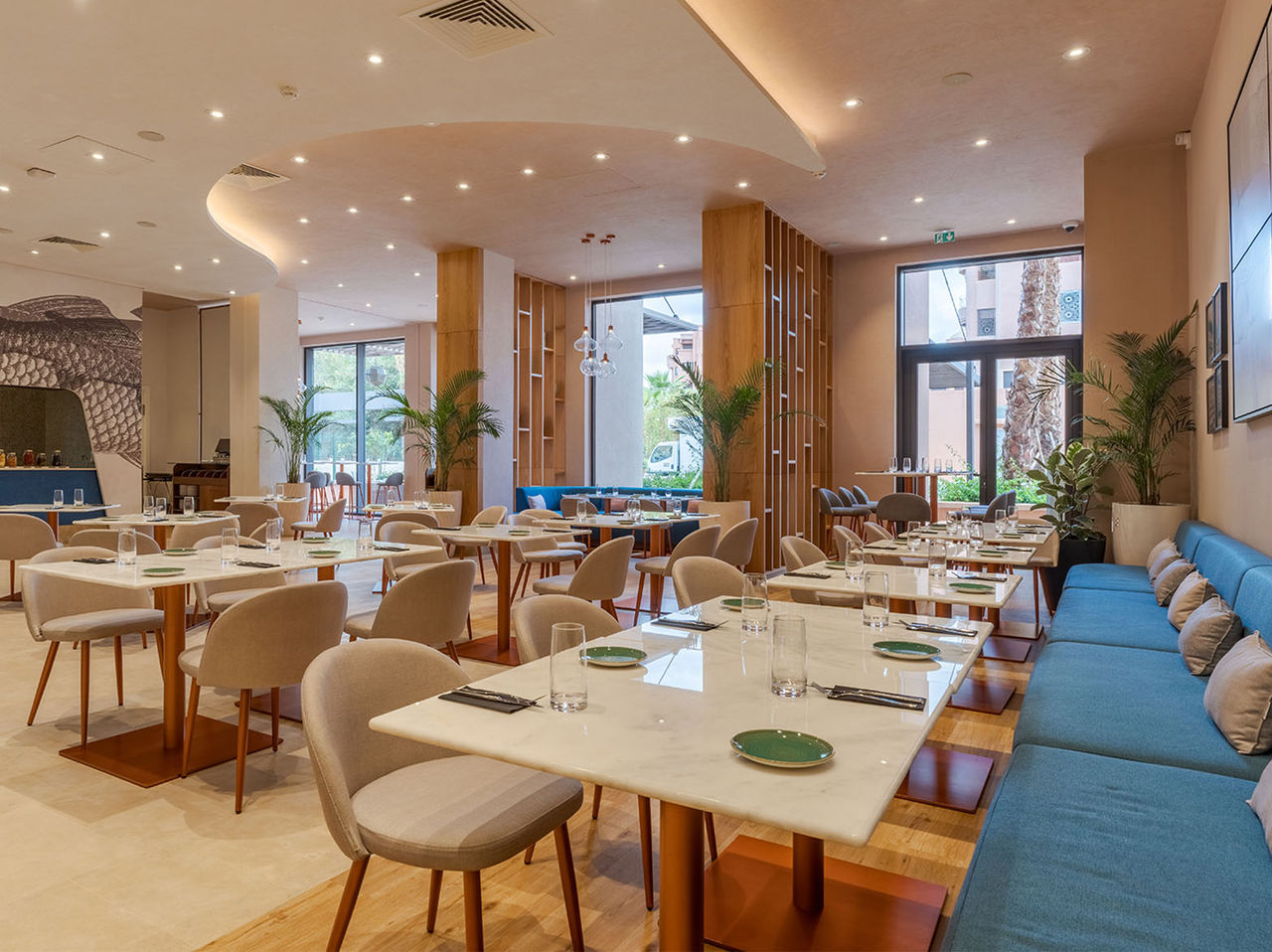 El restaurante Brasserie, del Hotel en el Centro de Marrakech, tiene varias mesas, decoración moderna y luz natural