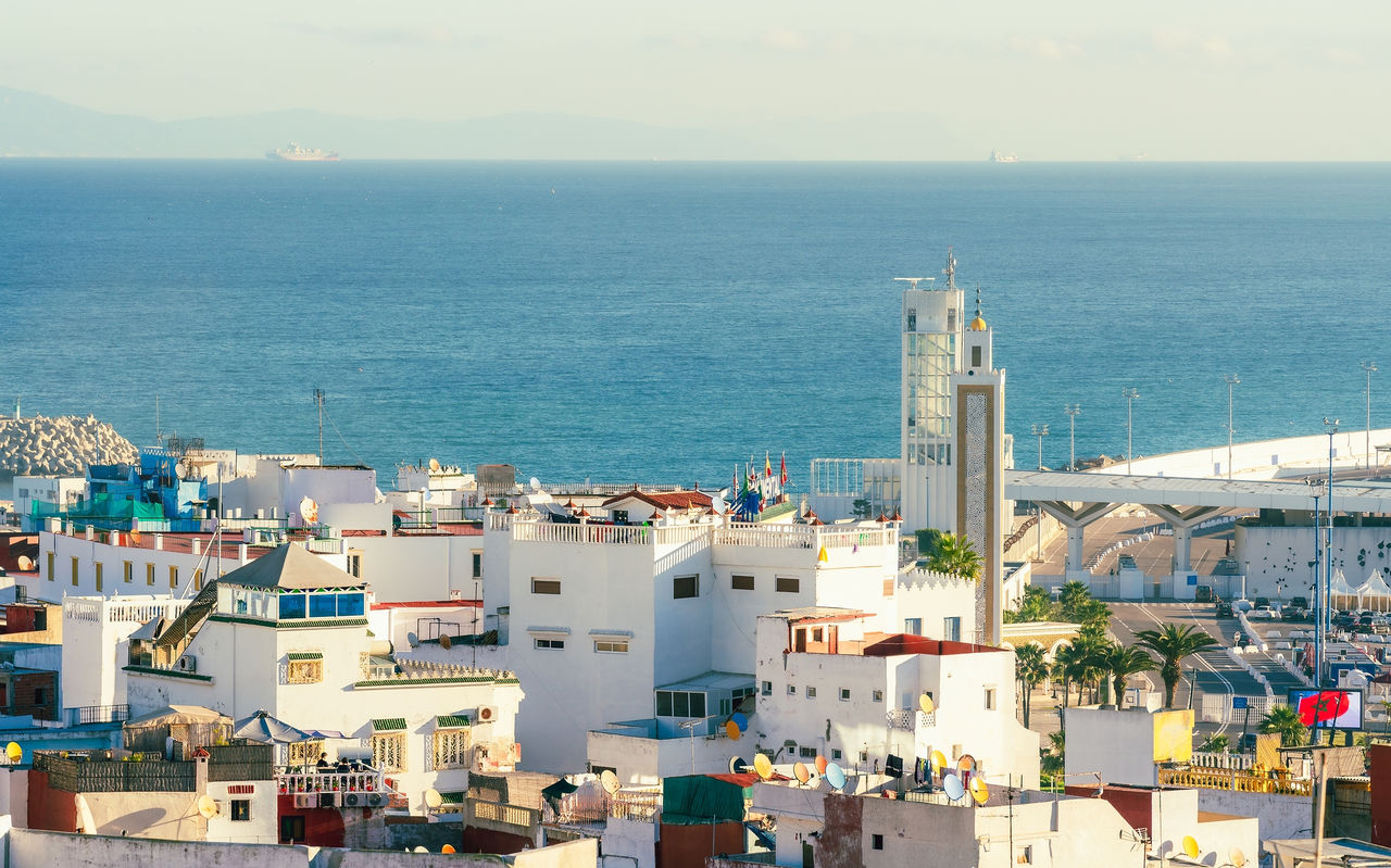 Vista de la ciudad de Tánger, Marruecos, con edificios blancos de arquitectura tradicional marroquí y mar azul de fondo
