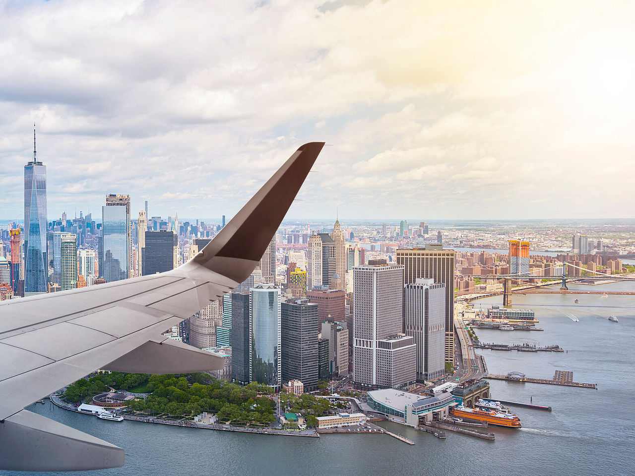 Explorá Hoteles en Nueva York con vista aérea del skyline de Manhattan y un ala de avión sobre el río
