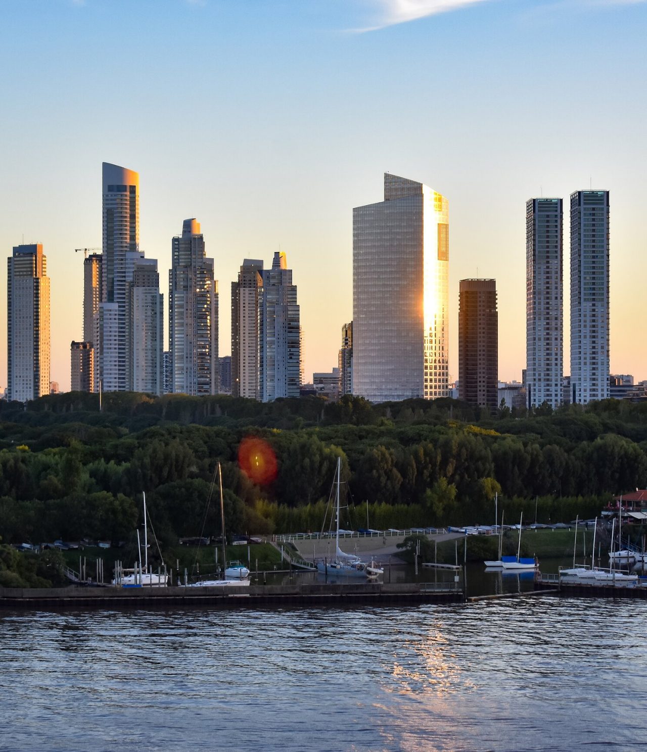 Vista del horizonte de Puerto Madero en Buenos Aires, con edificios modernos y la puesta de sol al fondo