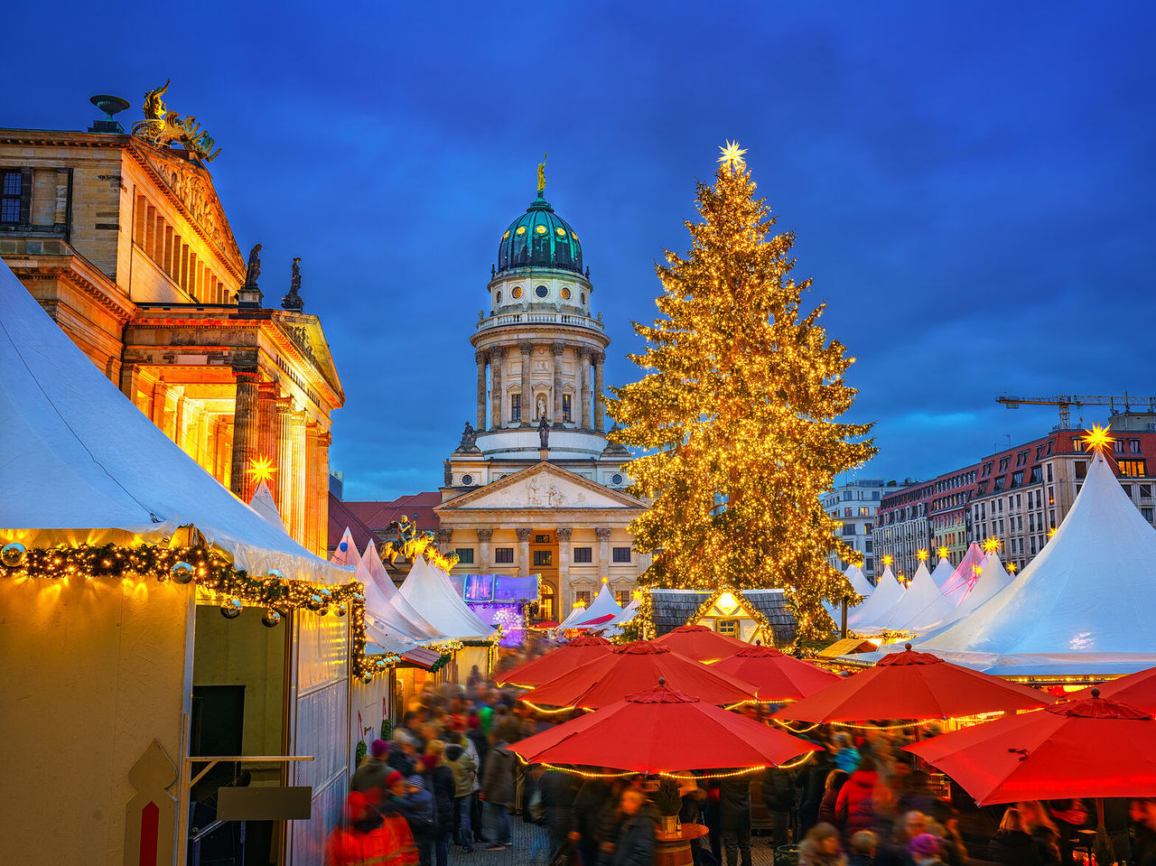 Catedral Francesa de Berlín iluminada, con un imponente árbol de Navidad en el centro de un mercado rodeado de puestos
