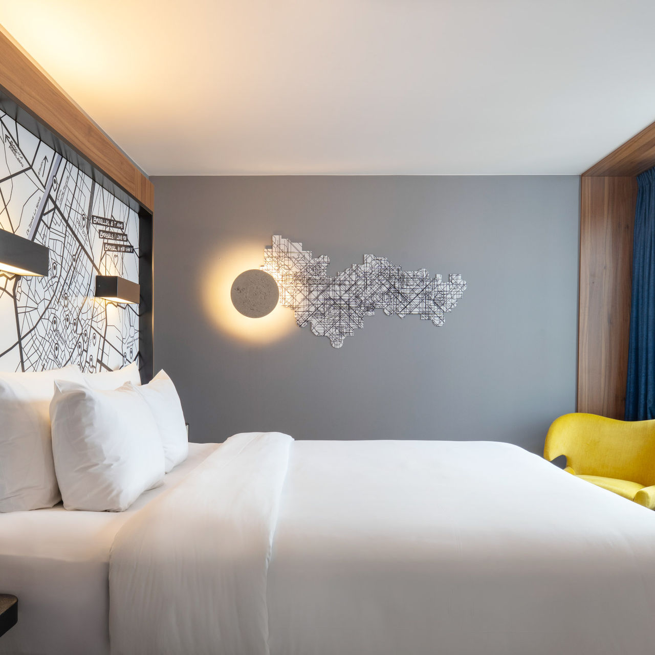 Cama doble con sábanas blancas en una habitación del Pestana Brussels Schuman, un hotel en Bruselas, Bélgica