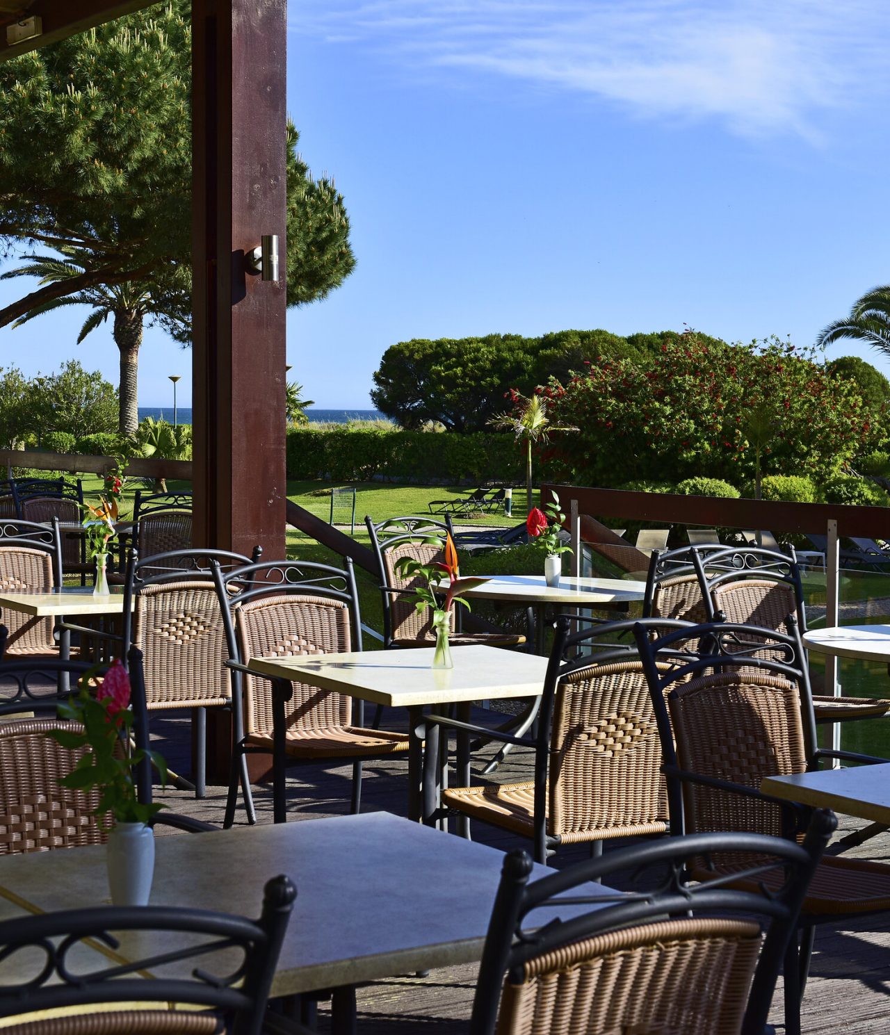 El restaurante Pavilhão do Rei, del Hotel 4 Estrellas en el Algarve, tiene una terraza con varias mesas y vista al jardín