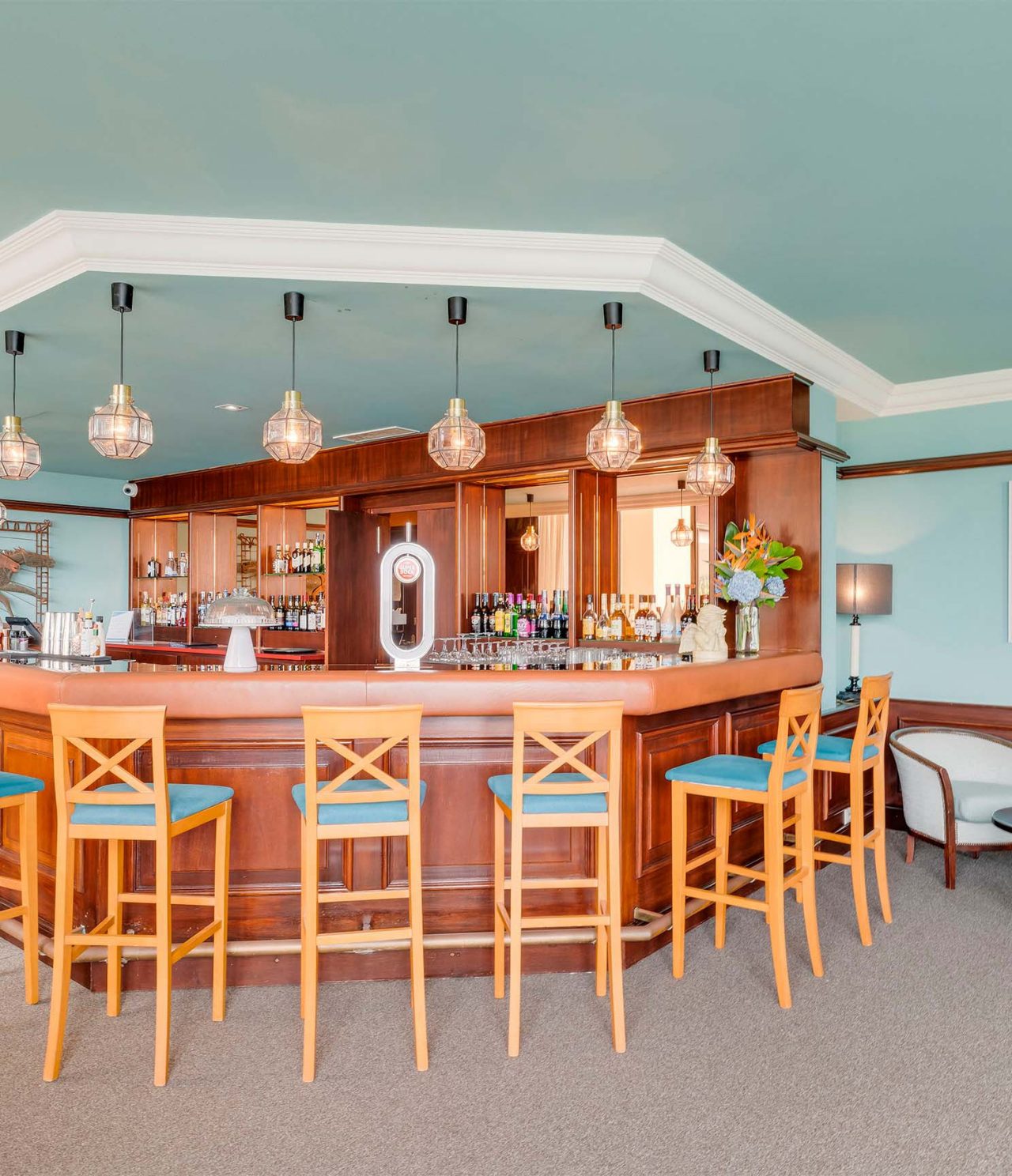 El bar Aqqua, del Hotel 4 Estrellas en los Azores, tiene un mostrador de madera con sillas para pedir bebidas