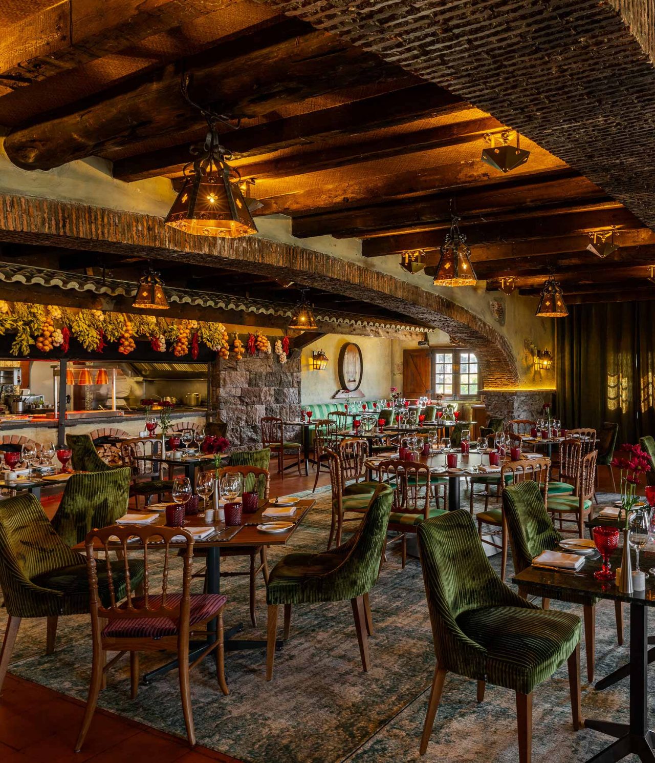 Restaurante del Pestana Carlton Madeira Hotel de 5 Estrellas en Madeira, con mesas iluminadas y vigas rústicas