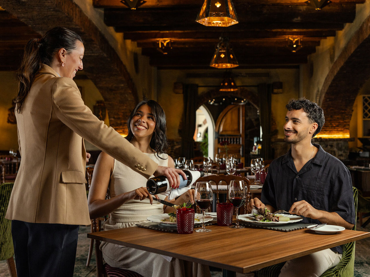 Restaurante del Pestana Carlton Madeira Hotel de 5 Estrellas en Madeira con pareja cenando y servicio de vino