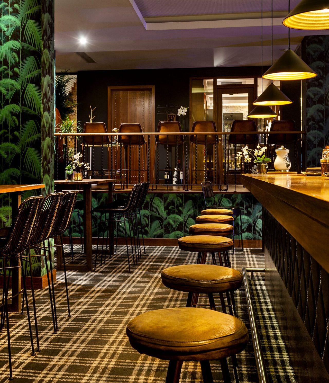 El Rib Bar del hotel 5 estrellas en el centro de Oporto, tiene un mostrador con bancos altos y papel tapiz tropical