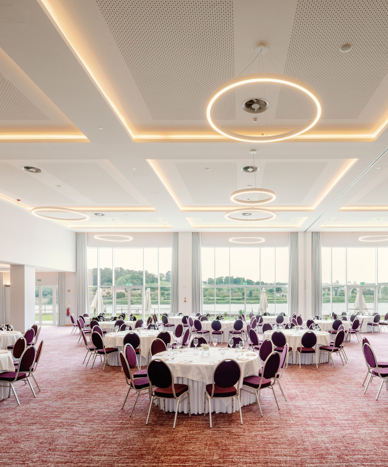 Reuniones y Conferencias en Pestana Hotel Group, en salas amplias y elegantes, con varias mesas redondas y luz natural