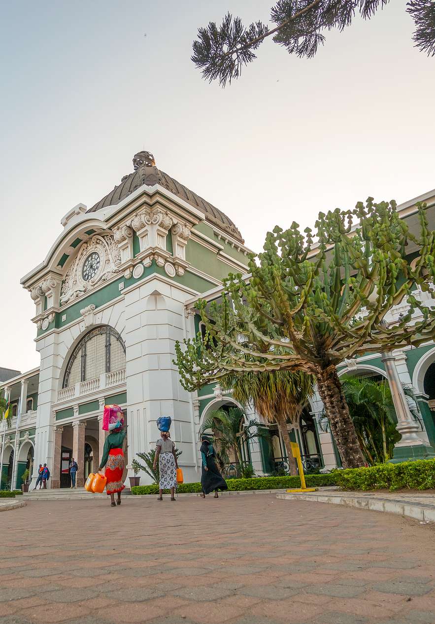 Pessoas deslocam-se para a estação de Maputo, um marco histórico da cidade com arquitetura clássica e detalhes ornamentais