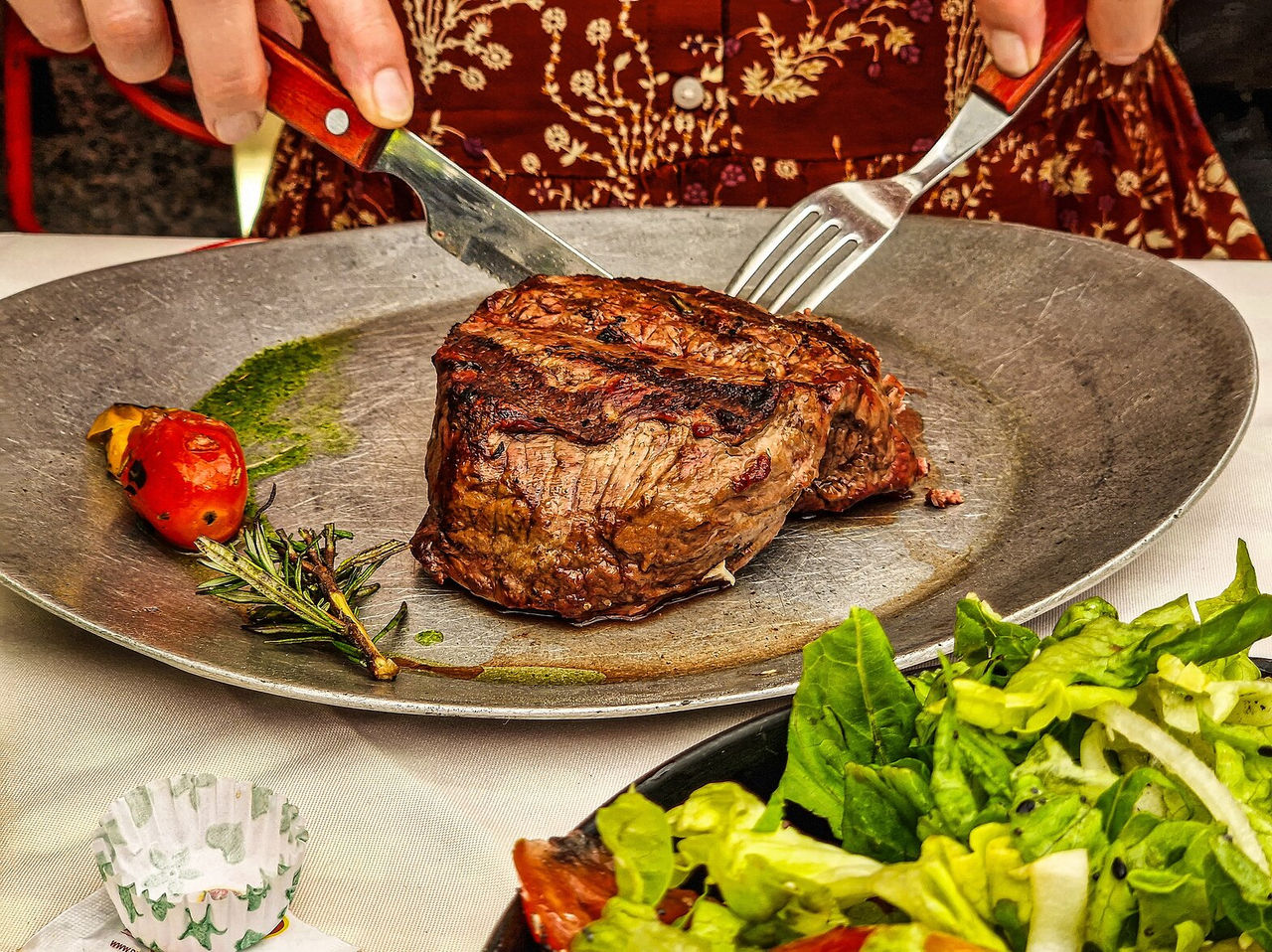 Prato de gastronomia típica da Argentina, composto por carne bovina, acompanhado de uma salada de alface e tomate