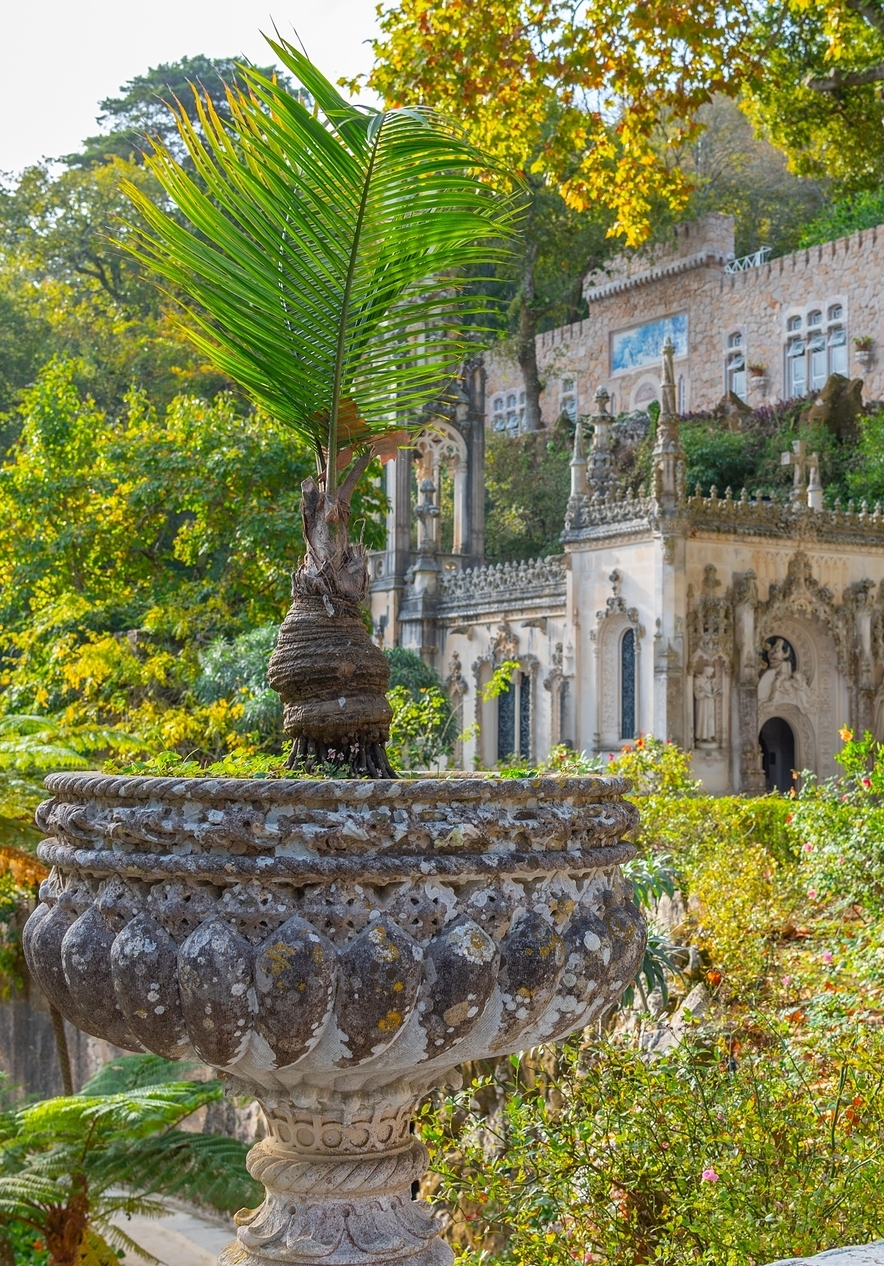 Quinta da Regaleira em Sintra, com fachada adornada de elementos góticos e românticos, rodeada pela intensa vegetação verde