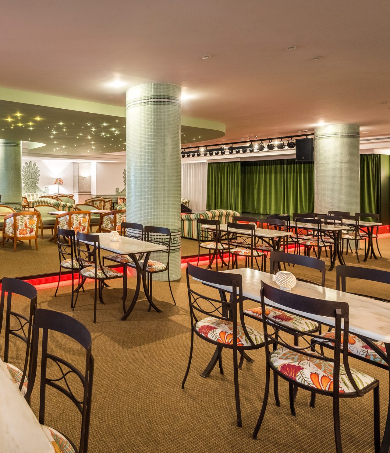 O bar Primavera Bar & Lounge, do Hotel 5 Estrelas no Funchal, tem um espaço interior amplo, com pilares verdes, e mesas