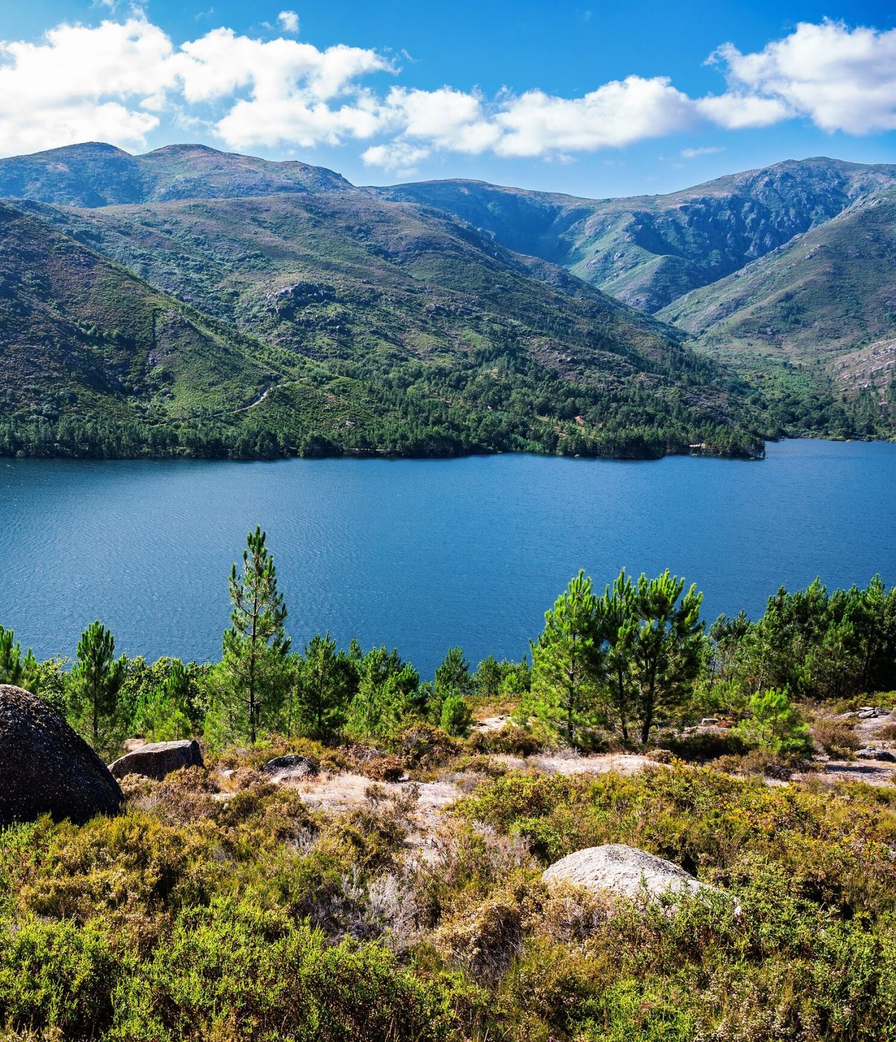 Paisagem montanhosa com rio douro no centro, rodeada por vegetação verde e rochas
