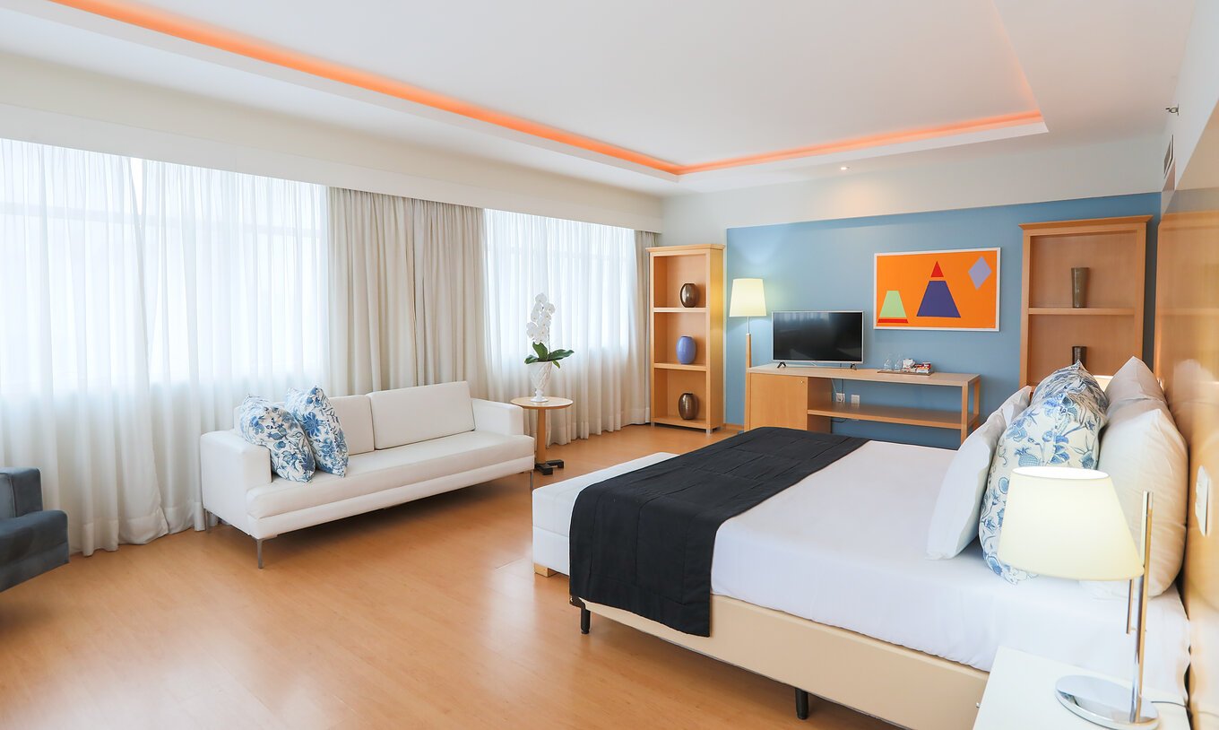 Die King Suite Executive im Pestana Curitiba ist ein geräumiges Zimmer mit vielen Fenstern, hell, mit Doppelbett und Sofa