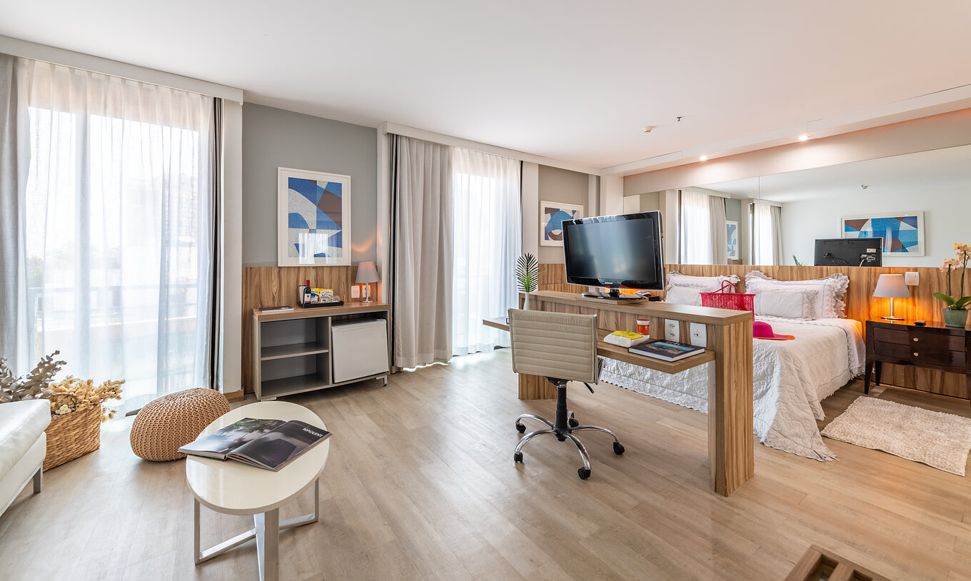 Die Junior Suite hat ein Doppelbett, einen Schreibtisch, Fernseher und zwei Fenster mit Vorhängen 