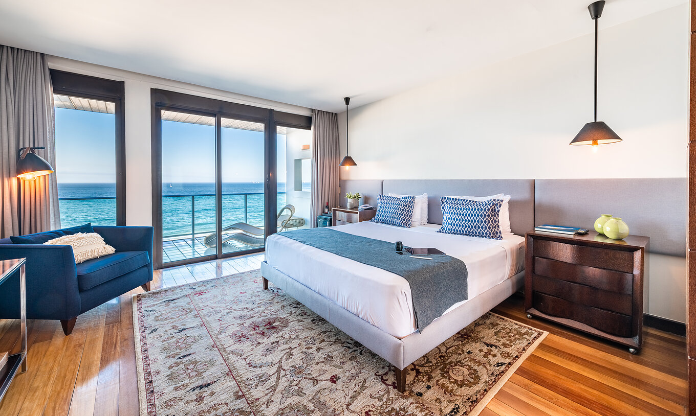 Die Präsidentensuite hat eine moderne Einrichtung, ein Doppelbett, einen Sessel und Balkon mit Meerblick 