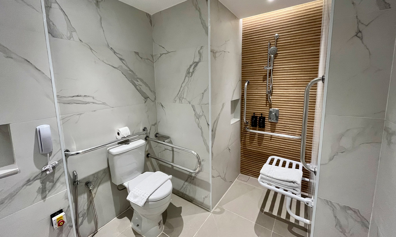 Das teiladaptierte Zimmer im Pestana Rio Atlântica hat ein barrierefreies Bad mit WC, Dusche und Haltegriffen