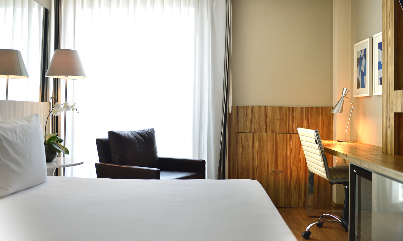 Das Standard Twin Zimmer hat ein Doppelbett, einen Sessel und einen Schreibtisch mit bequemer Stuhl 