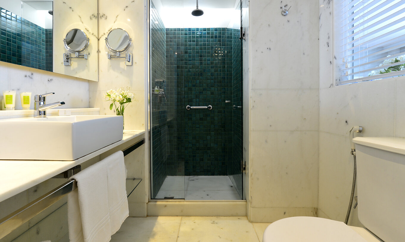 Das Twin Zimmer mit seitlichem Meerblick hat ein Bad mit Dusche, Toilette, Waschbecken und Spiegel 