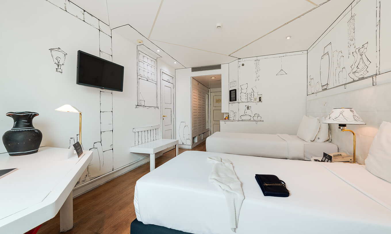 Das Art Room im Pestana São Paulo hat zwei Betten und schwarz-weiße Gemälde von Elano Passos