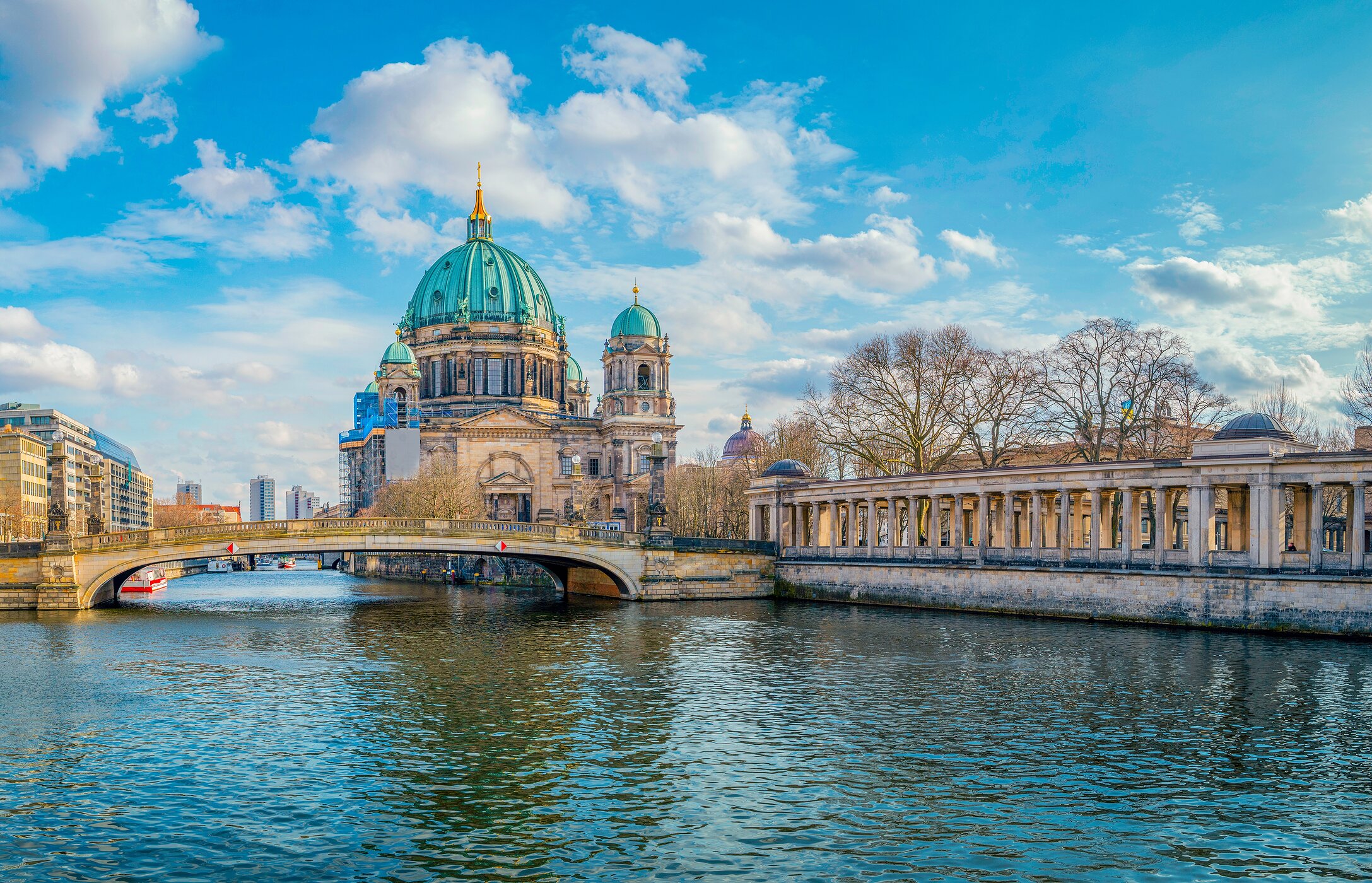 Blick auf den berühmten Berliner Dom, mit einer Fußgängerbrücke davor und dem Fluss, der darunter fließt