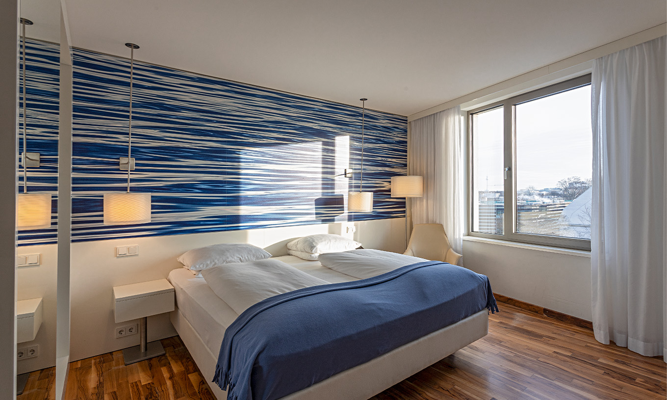 Das Deluxe Zimmer im Obergeschoss im Pestana Berlin Tiergarten hat ein Doppelbett und ein Fenster mit Stadtblick