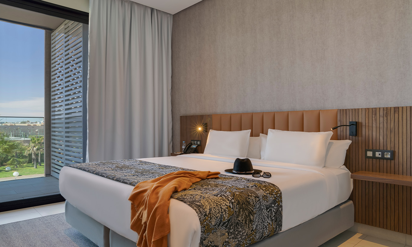Die Premium-Suite im Pestana Casablanca hat ein Schlafzimmer mit Doppelbett und Balkon