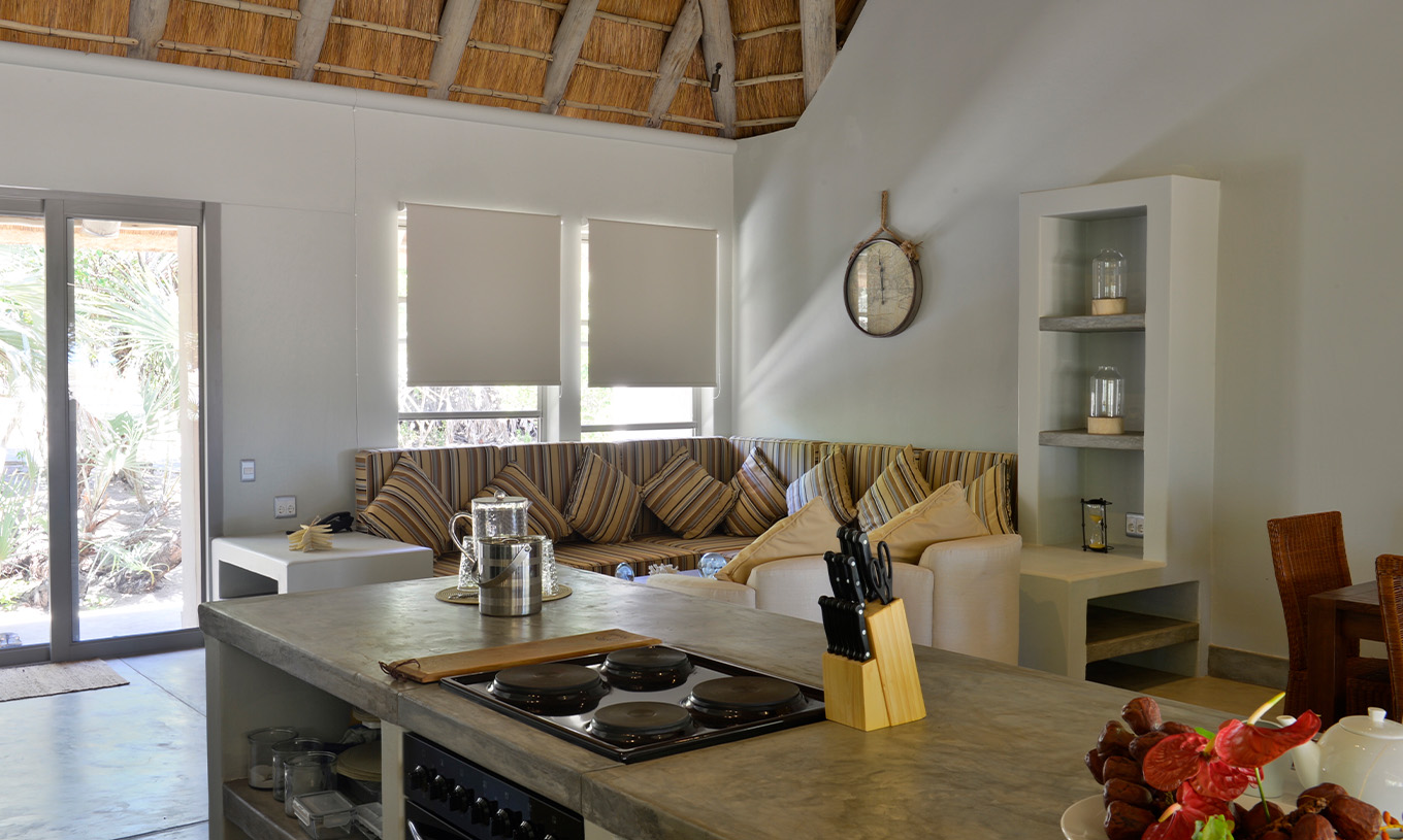 Die T2 Villen im Pestana Bazaruto Lodge haben ein Wohnzimmer mit Sofas und Esstisch und eine offene Küche