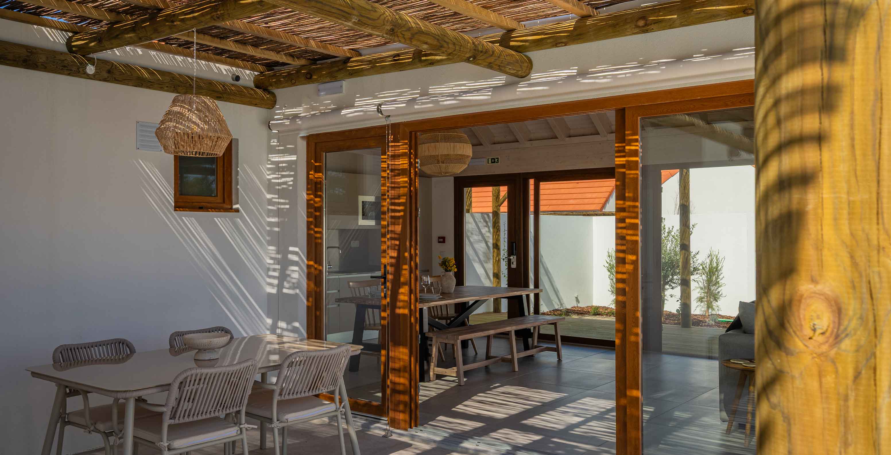 Die Premium Green Villa im Pestana Comporta Village Residences hat eine überdachte Terrasse mit Tisch, der ins Innere führt