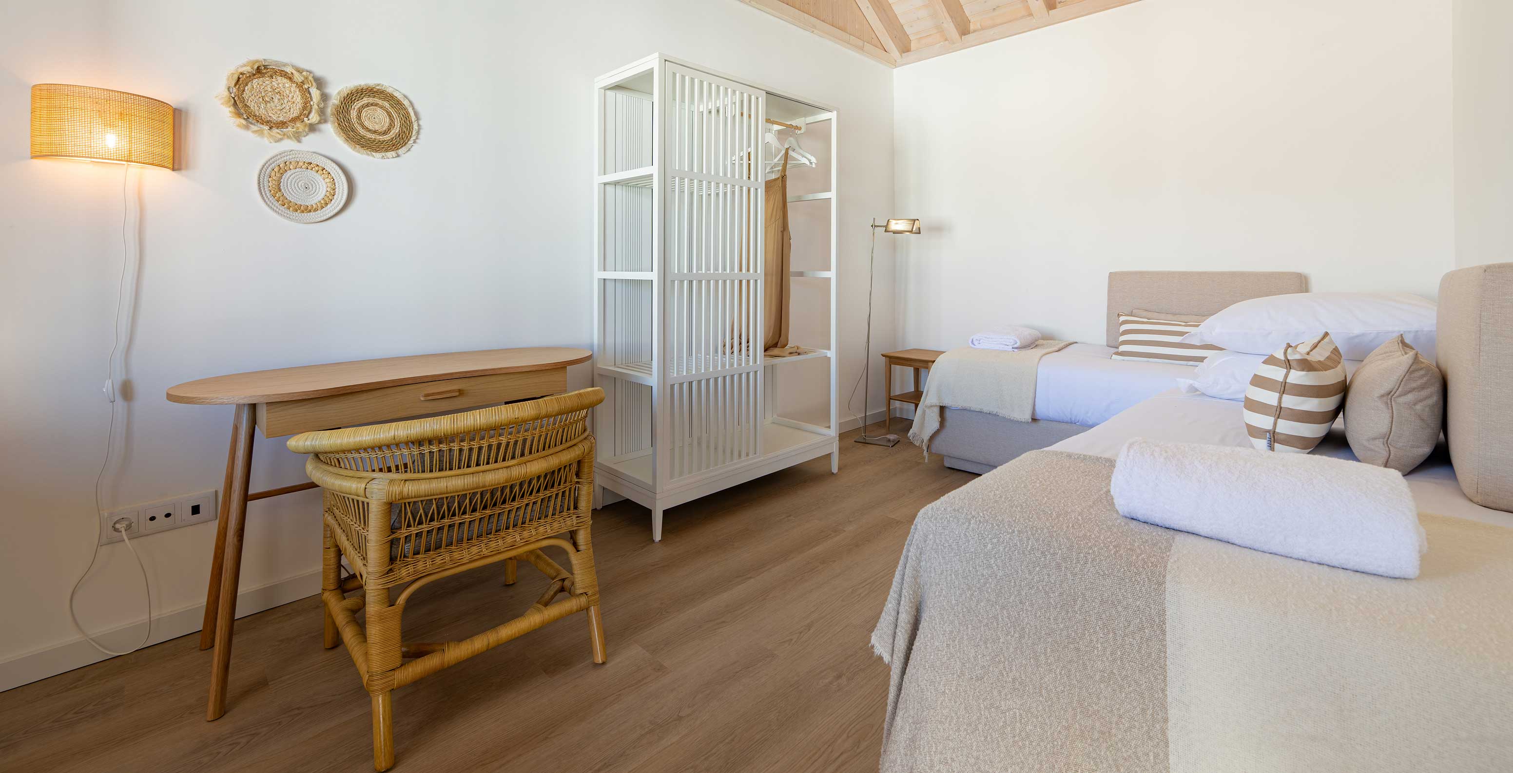 Die Standard Villa im Pestana Comporta Village Residences verfügt über ein Schlafzimmer mit Bett, Tisch und einem Korbstuhl