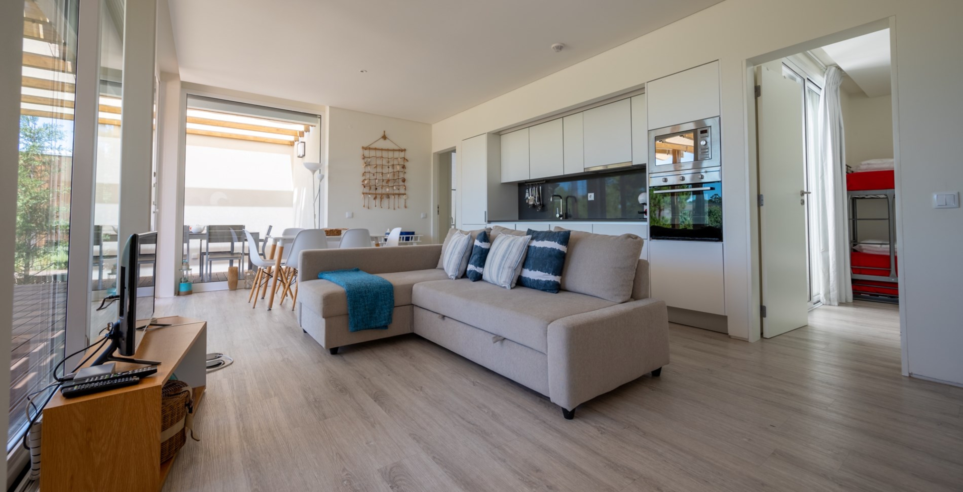 Die Green Villa mit privatem Pool im Pestana Tróia Eco Resort hat einen Wohnbereich mit Küche, Sofa, Tisch und Fernseher