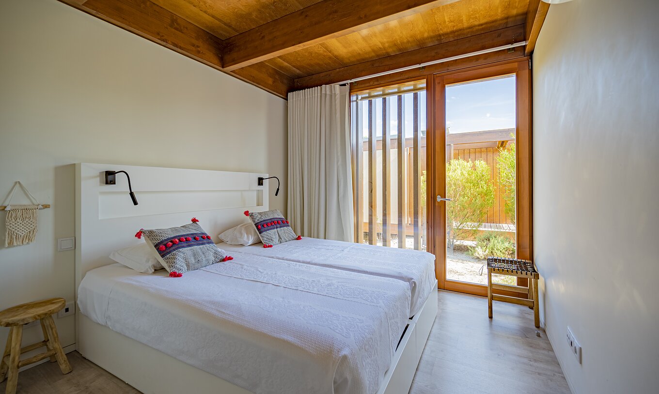 Tree Villa mit Privatpool Pestana Tróia Eco Resort hat ein Doppelbett und ein großes Fenster