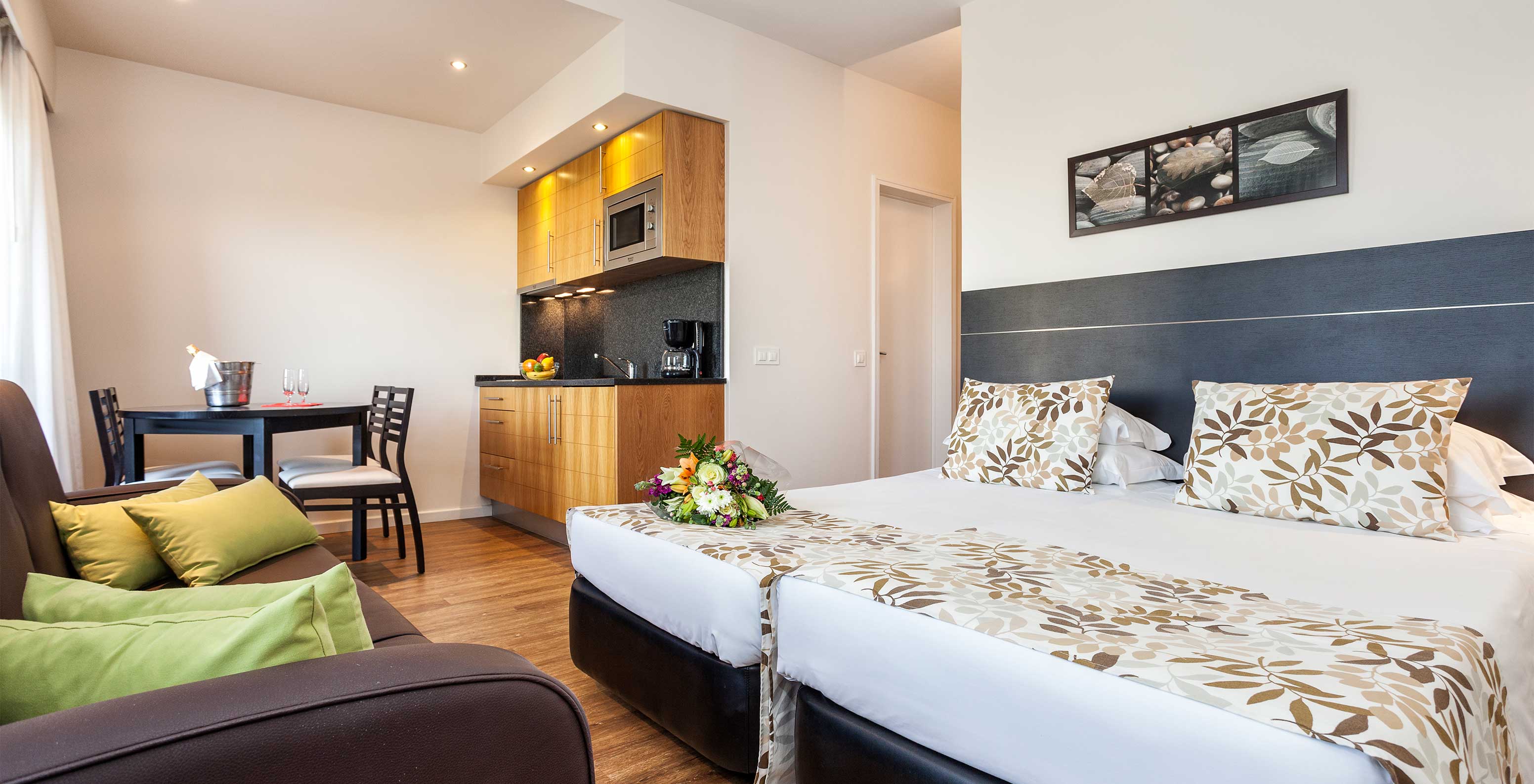 Das Gartenblickstudio des Pestana Alvor Atlântico ist ein Apartment mit Bett, Sofa und Küchenzeile