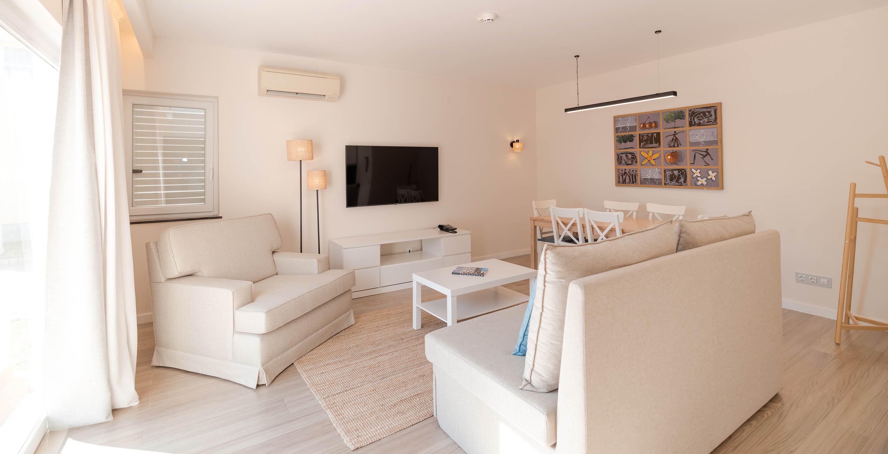 Villa 2 Schlafzimmer Premium im Pestana Alvor Beach Villas hat Wohnzimmer mit beigen Sofas, TV und Klimaanlage