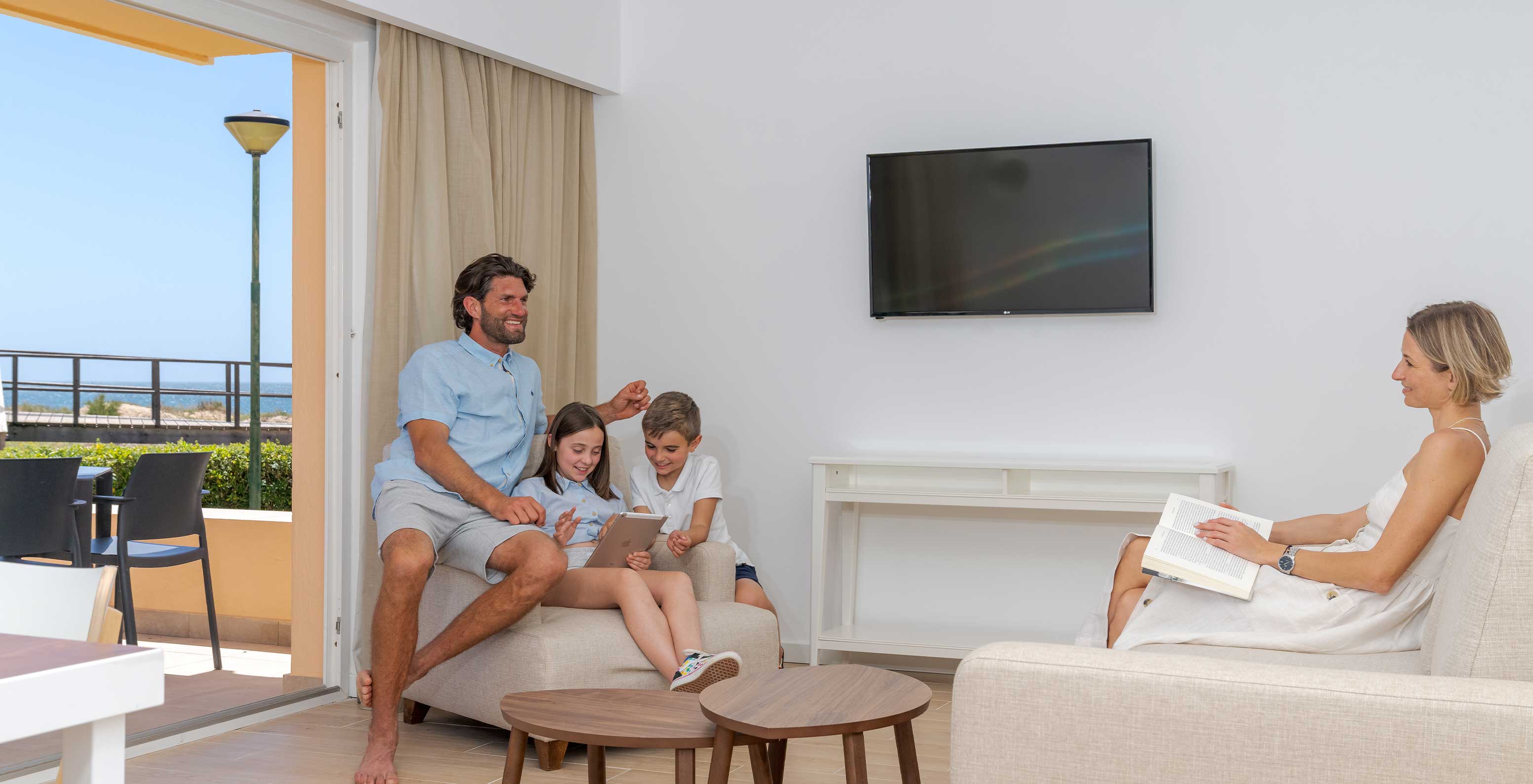 Familie genießt wertvolle Zeit auf den Sofas der Pestana Alvor Beach Villas