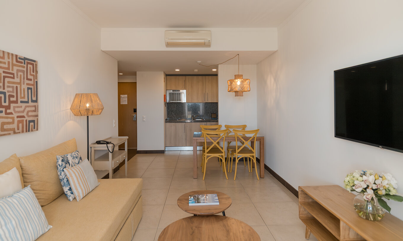 Apartment T1 Gartenblick im Pestana Alvor Beach Villas hat ein Wohnzimmer mit Sofa, TV und Esstisch