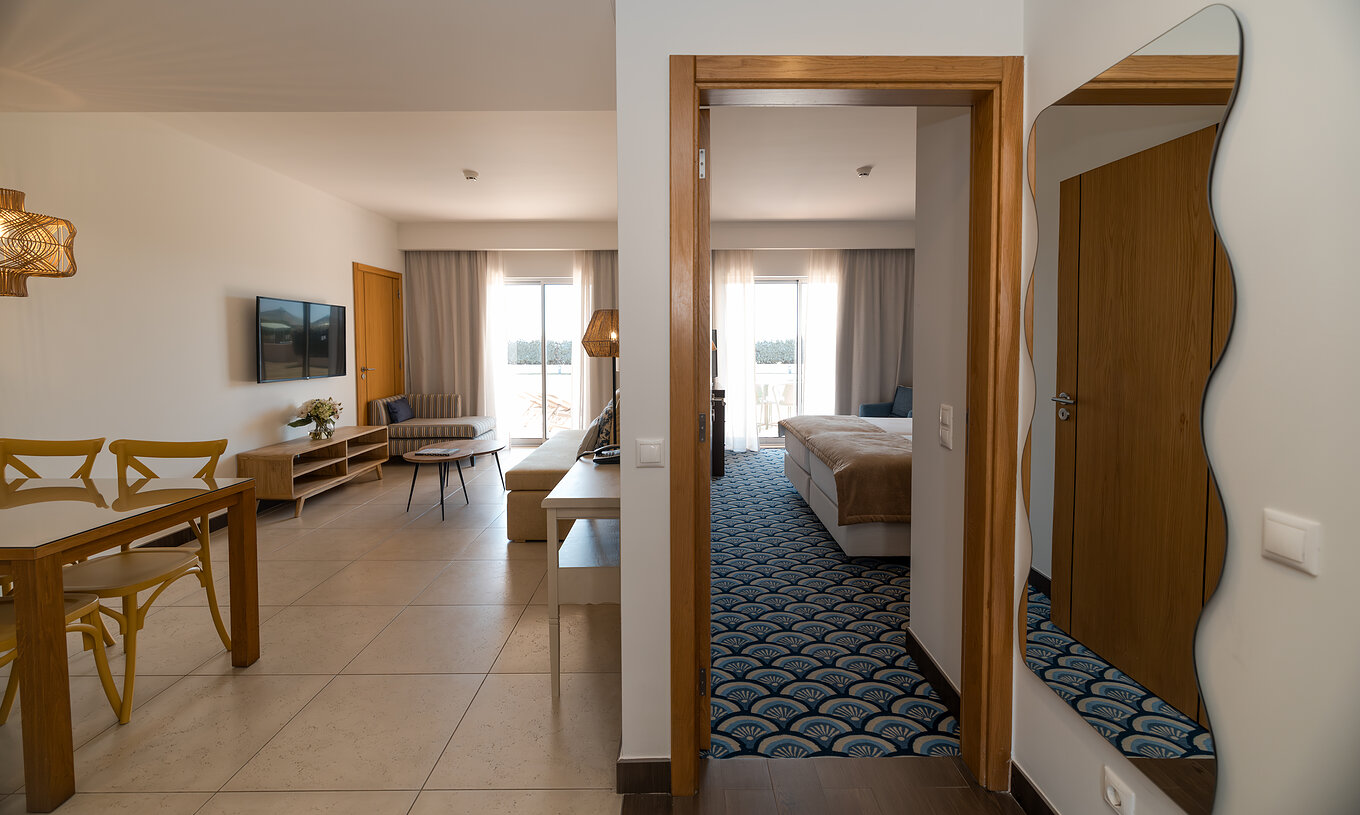 Apartment T1 Gartenblick im Pestana Alvor Beach Villas hat ein Wohnzimmer mit Sofa, TV und Fenster mit Balkon