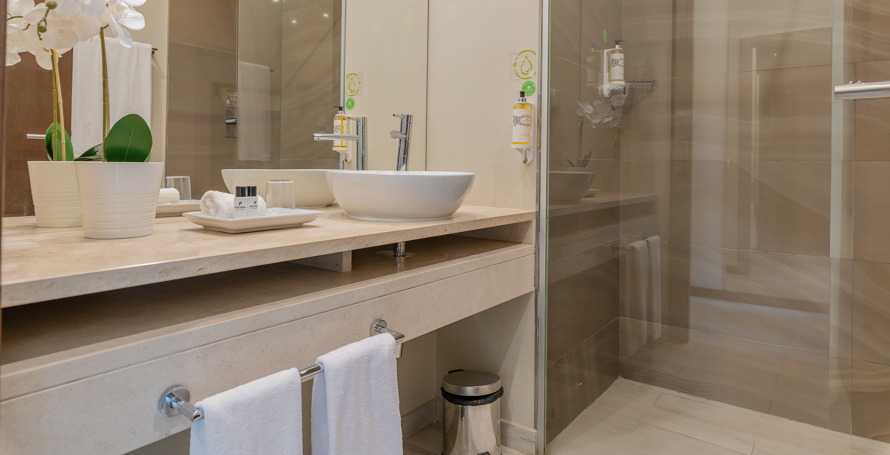 Die Garden Suite im Pestana Alvor Park hat ein Badezimmer mit Badewanne und Waschbecken mit einer Blumenvase