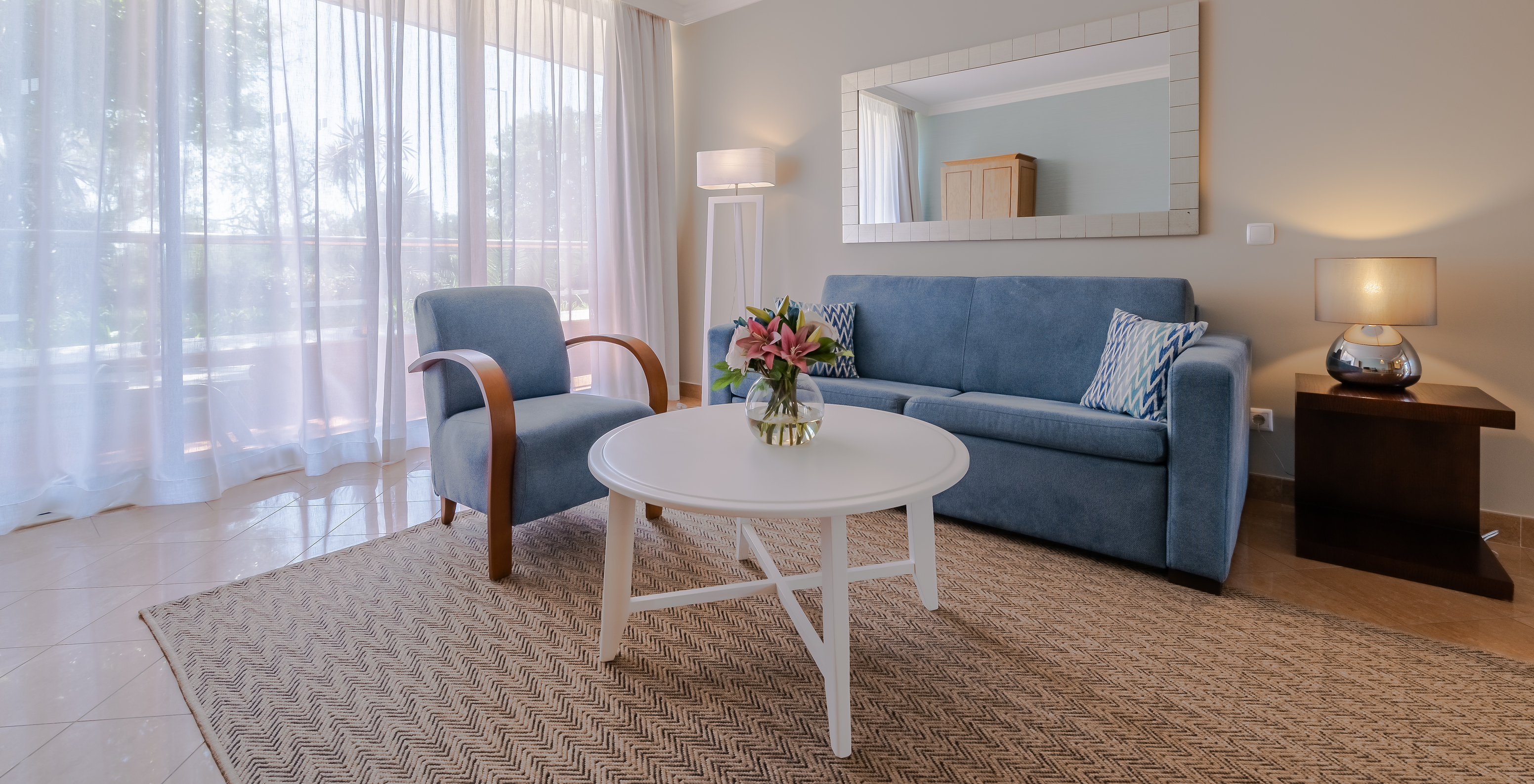 Das T1 - mit 1 Schlafzimmer im Pestana Alvor Park hat ein Wohnzimmer mit einem blauen Sofa und einem Sessel