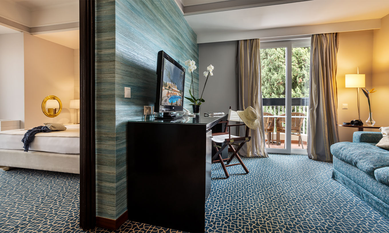 Die Suite mit Gartenblick im Pestana Alvor Praia hat einen Raum mit Sofa, Schreibtisch und Fernseher und Schlafzimmer