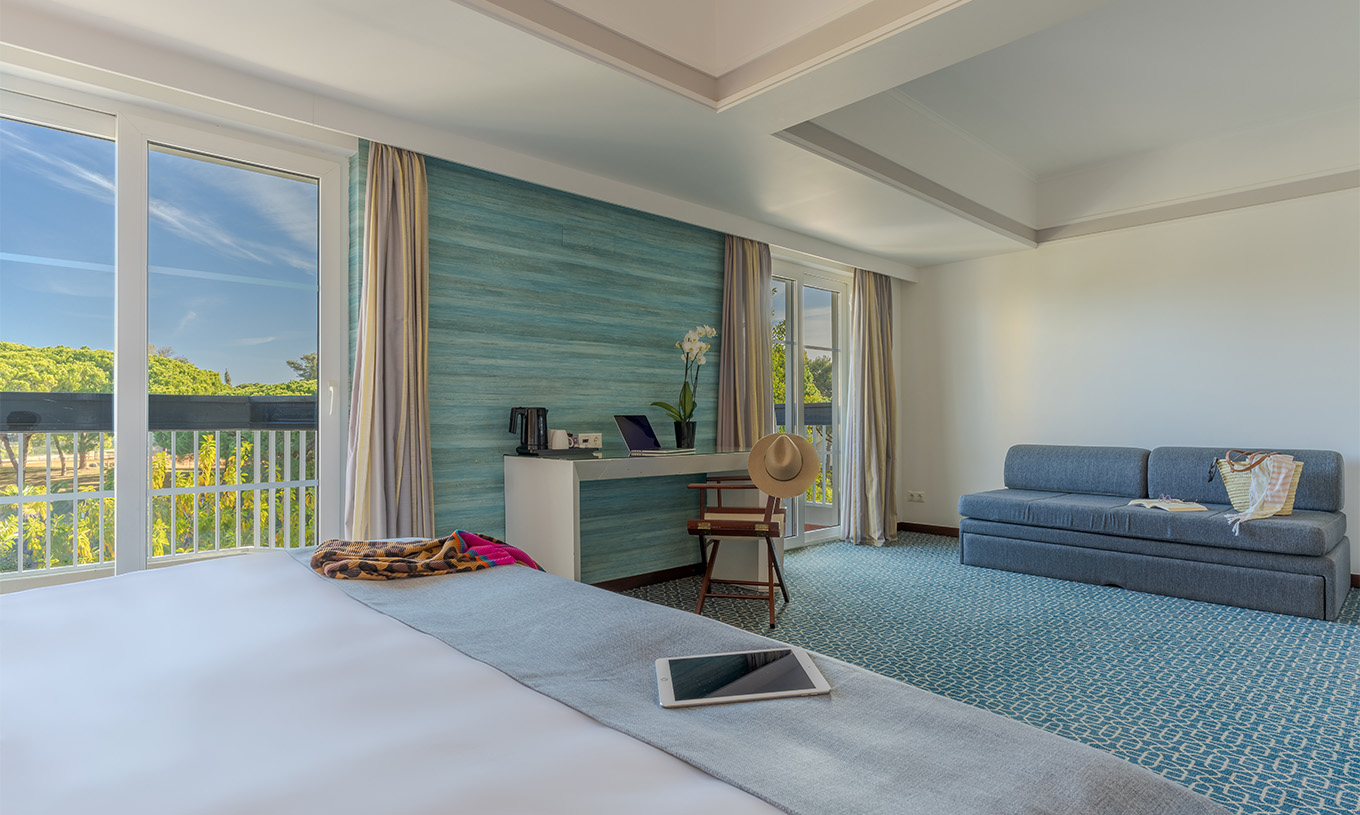 Das Superior im Pestana Alvor Praia hat ein Doppelbett, ein Sofa, ein Schreibtisch und große Fenster mit Gartenblick