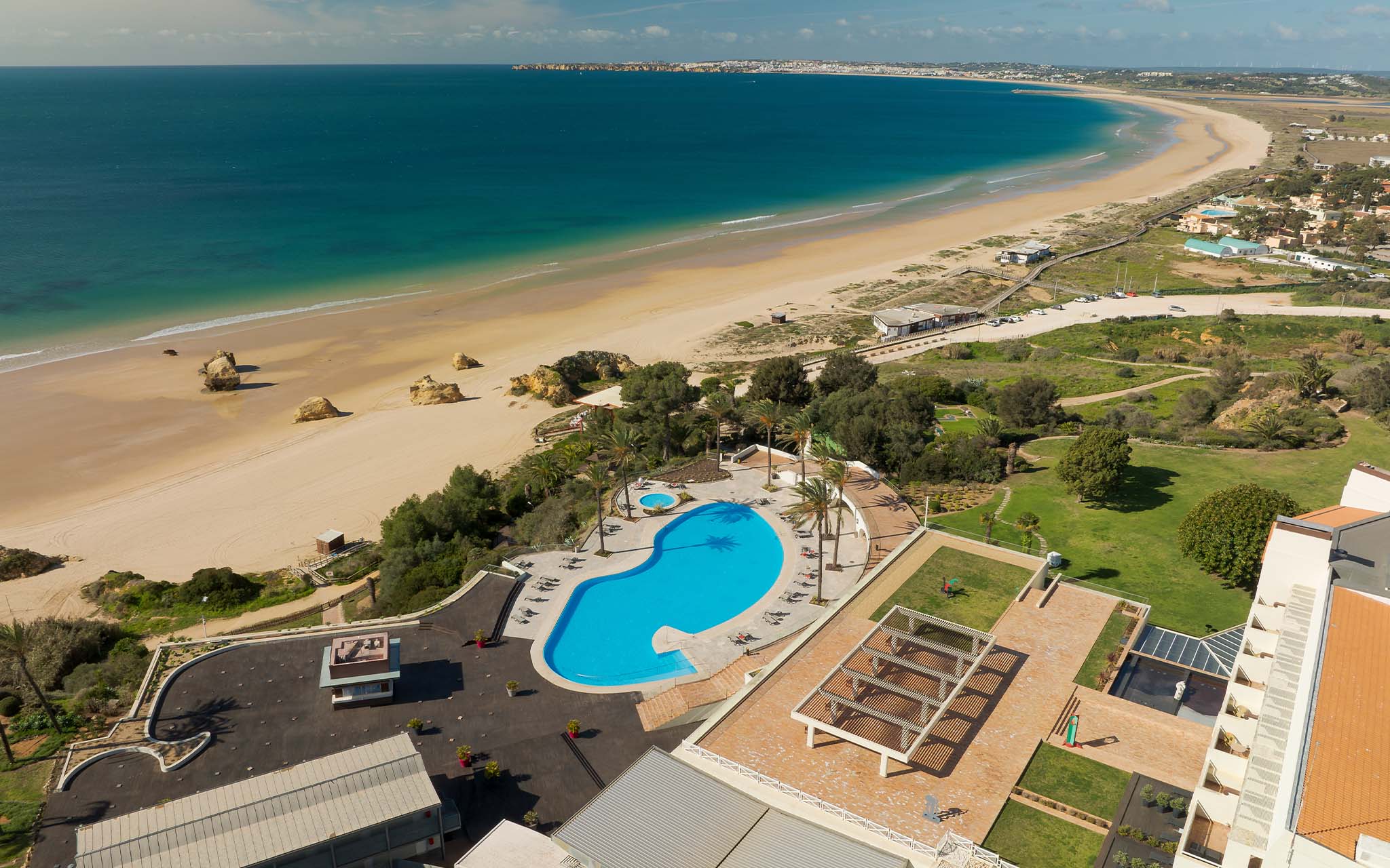 Blick von oben auf den Pool des Pestana Alvor Praia mit direktem Zugang zum langen Sandstrand