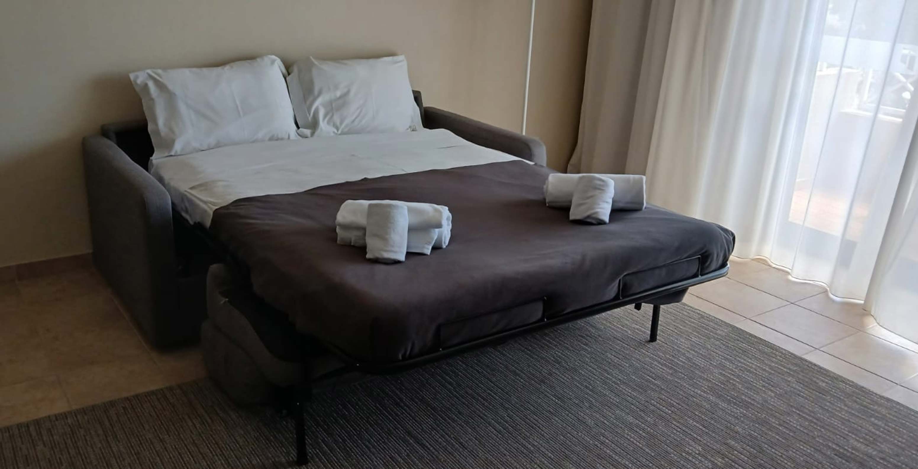 Das Studio im Pestana Gramacho Residences hat ein offenes Schlafsofa mit weißen Laken und Handtüchern