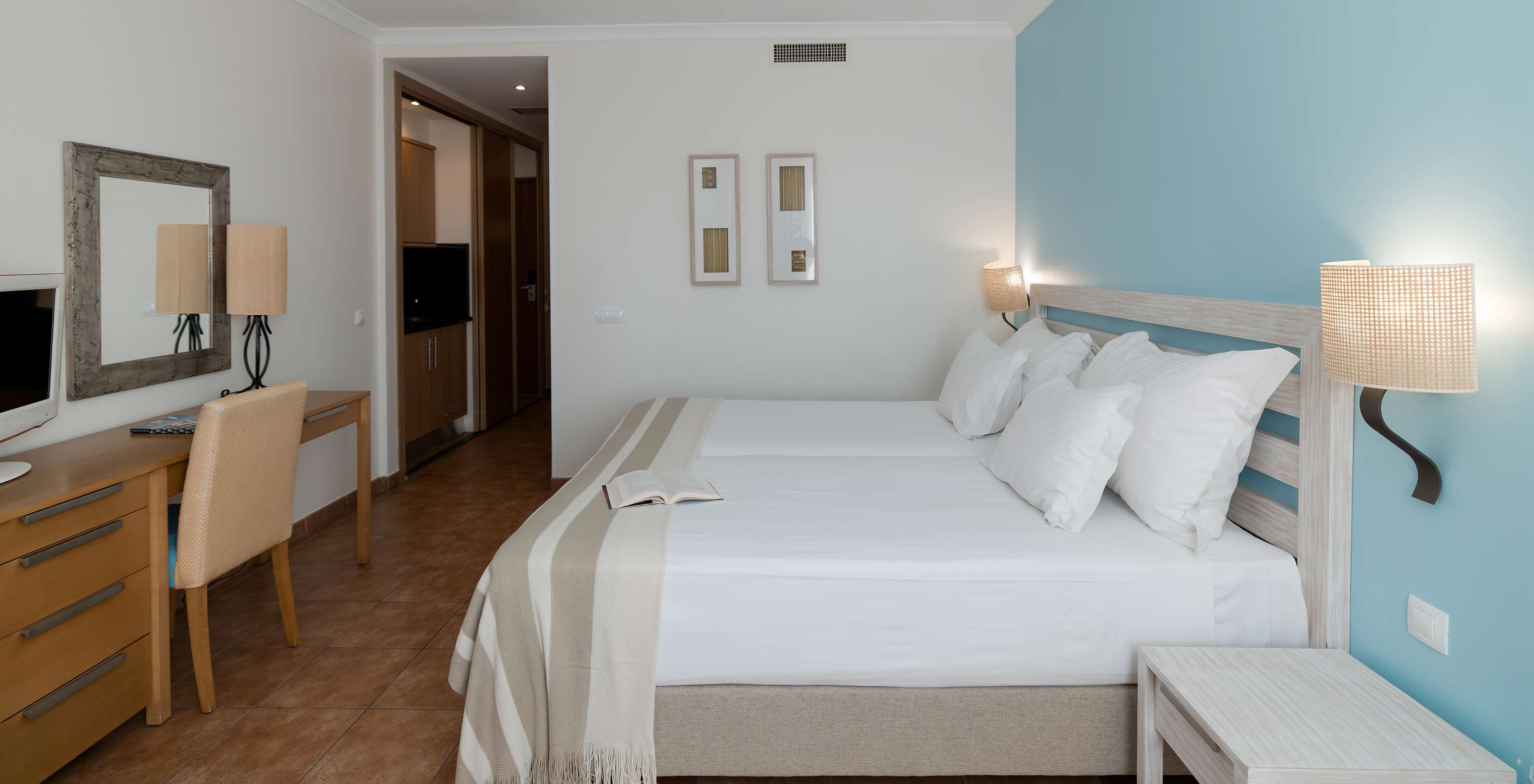 Das Deluxe Meerblick im Pestana Viking hat zwei Betten, Nachttisch und Schreibtisch mit Stuhl