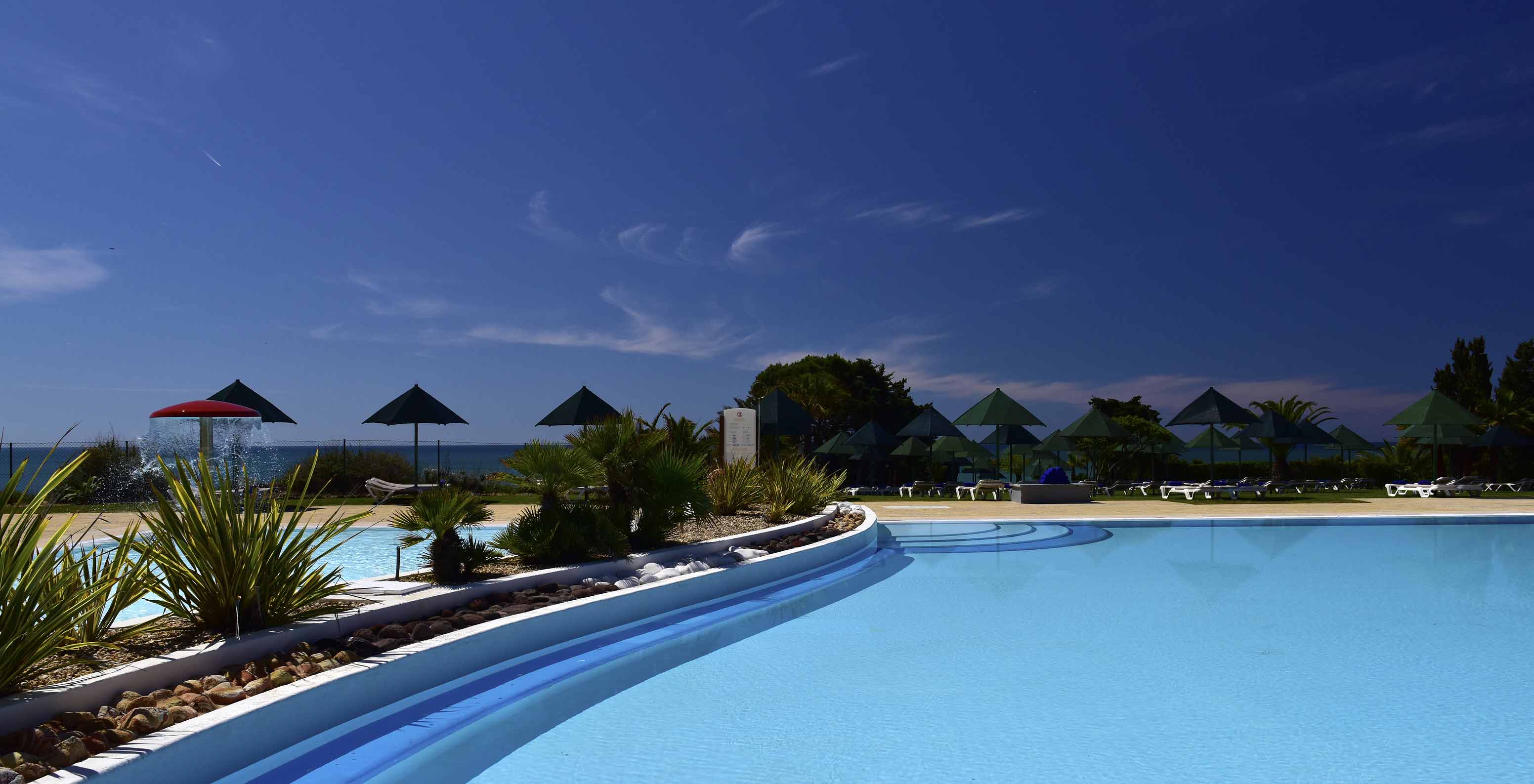 Das Pestana Viking hat einen Außenhof mit Pool Liegen mit Schirmen und Blick auf das Meer