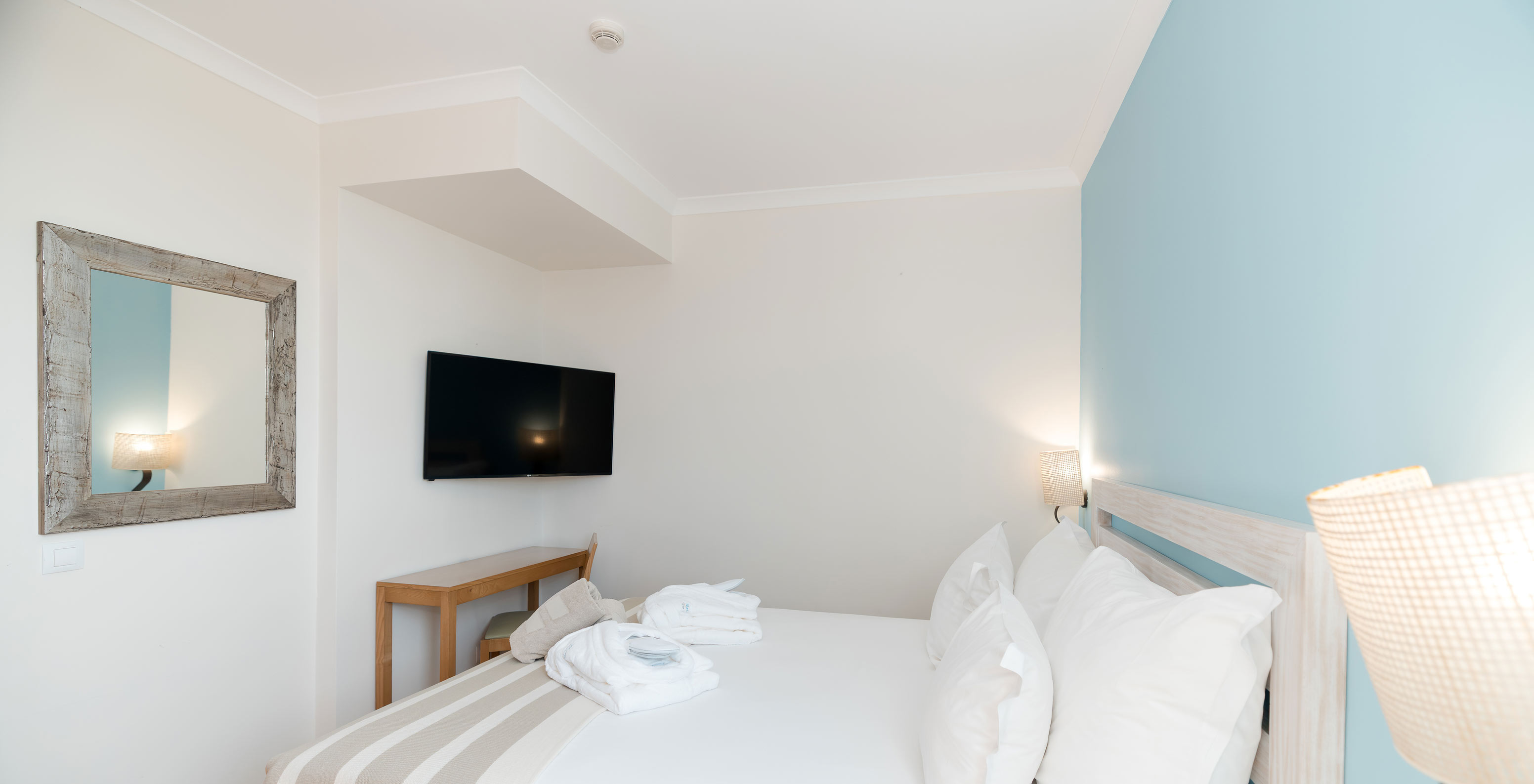 Die T2 Suite im Pestana Viking hat ein Zimmer mit Doppelbett, Fernseher und Spiegel