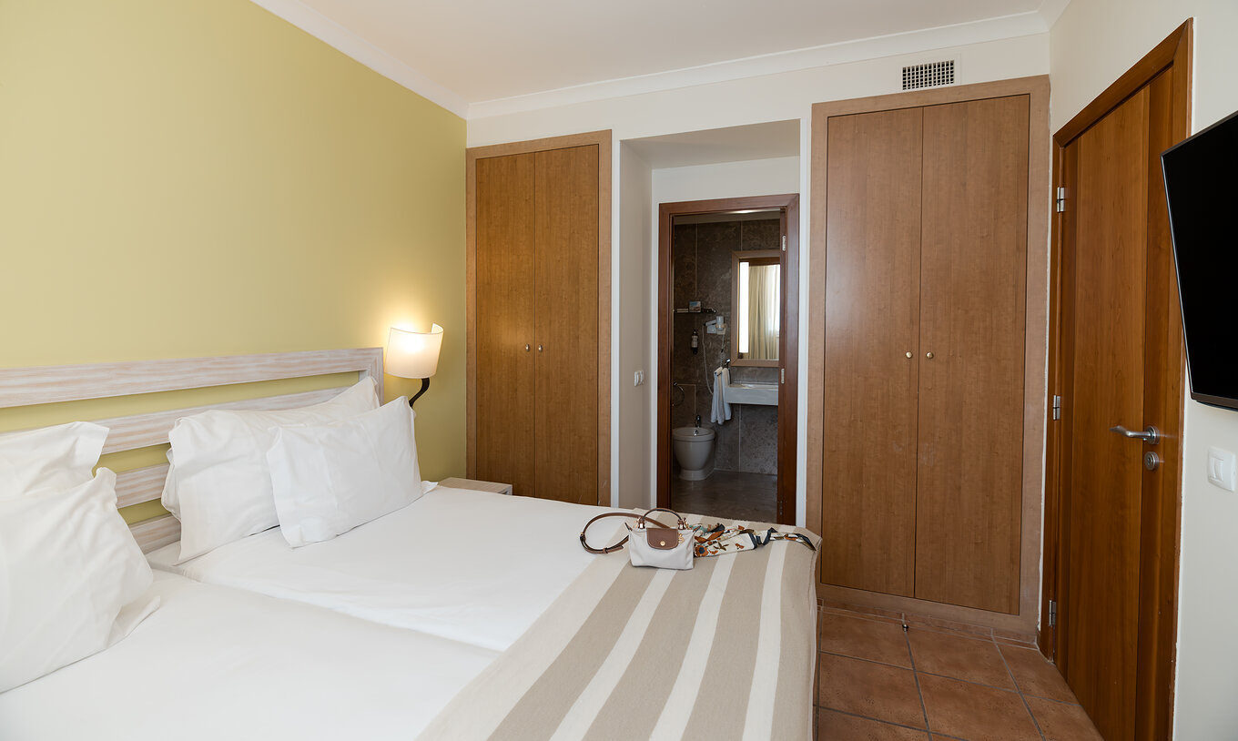 Die T2 Suite im Pestana Viking hat ein Zimmer mit zwei Betten, Nachttisch und Bad