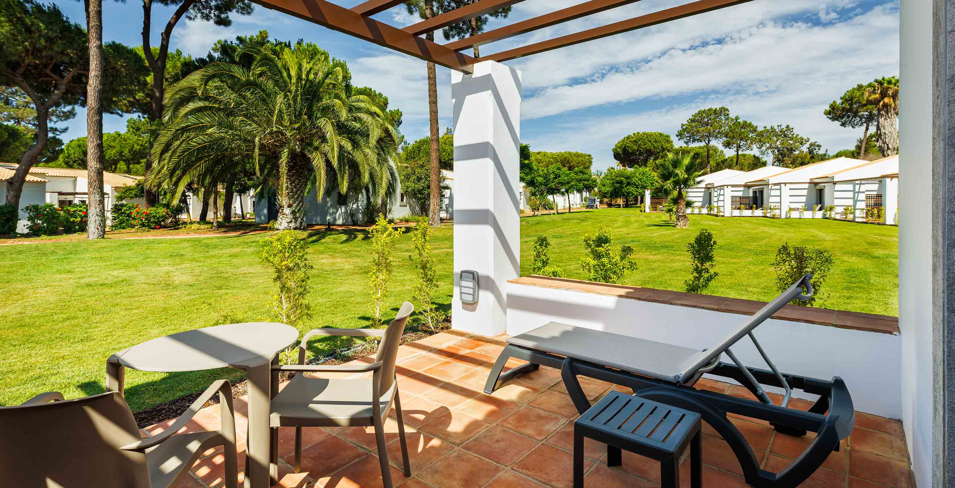 Das Family Garden View im Pestana Vila Sol - Vilamoura hat Balkon mit Liegestuhl, Tisch und Gartenblick