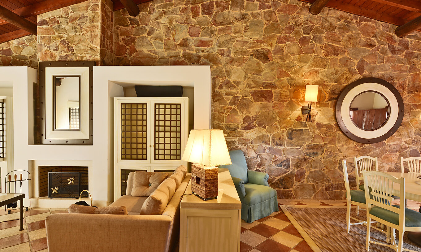 Die Gartenblick Suite Vila Sol im Pestana Vila Sol - Vilamoura hat ein Wohnzimmer mit einem Sofa, Kamin und Esstisch