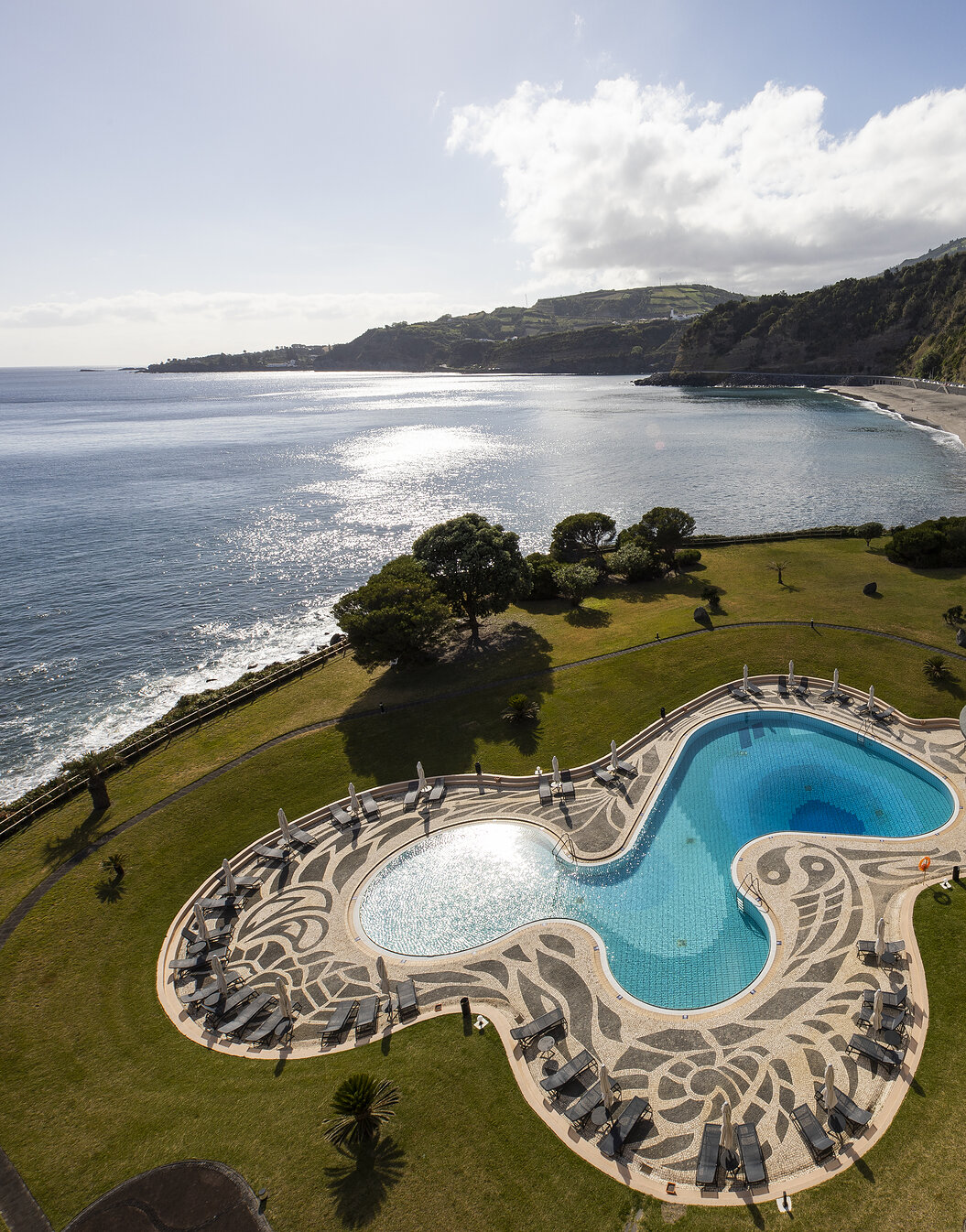 Pool mit Meer- und Strandblick im Pestana Bahia Praia auf São Miguel an einem teilweise bewölkten Tag